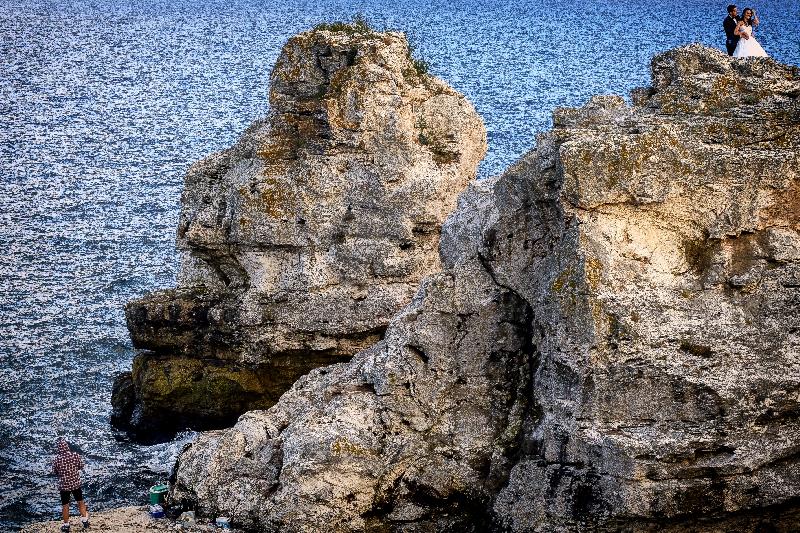 photo pecheur sur rocher dans la mer 