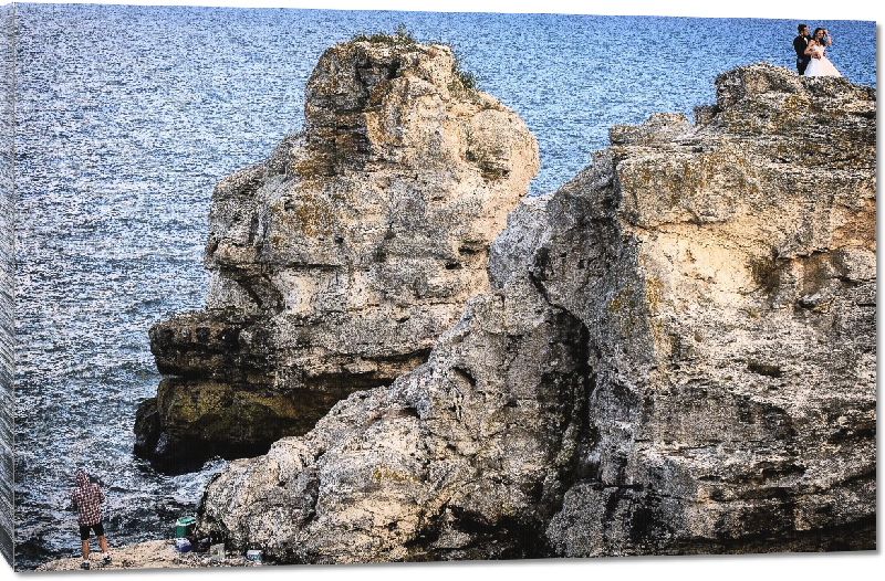 Toiles imprimées photo pecheur sur rocher dans la mer 