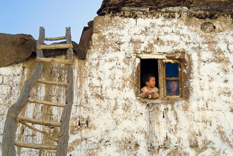 Photo jeune garçon et mère dans la fenêtre de la maison traditionnelle de village Zanskari, échelle de toit, Reru