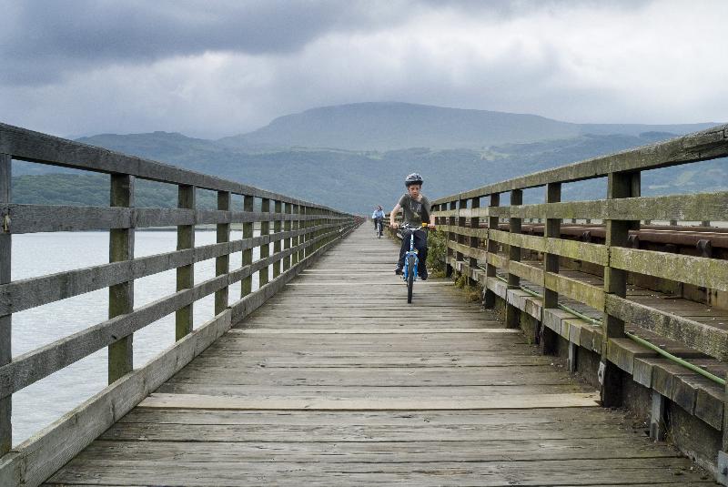 Photo  Cyclistes sur le pont Barmouth traversant l'estuaire de la rivière Mawddach, Barmouth, Gwynedd, N.-Galles, Royaume-Uni