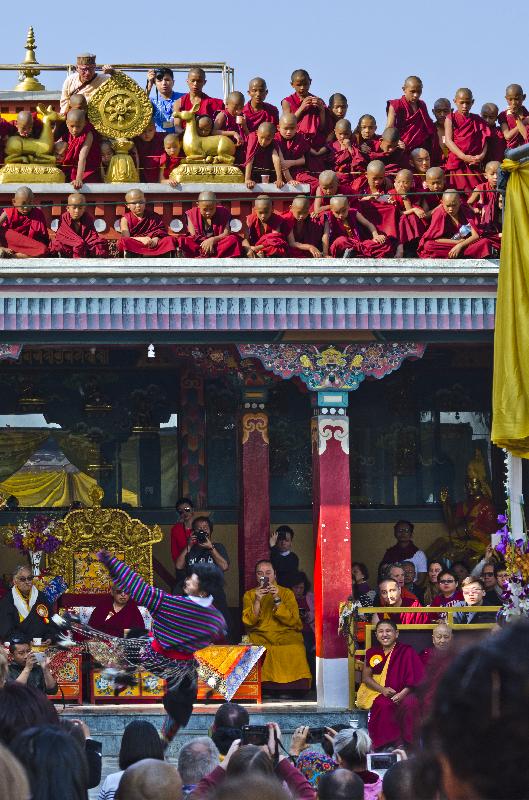 Photo novices bouddhistes tibétains entassant le toit du monastère autour d'un Dharmachakra à 8 rayons