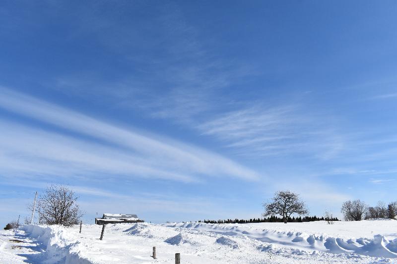 Une ferme en hiver sous un ciel bleu