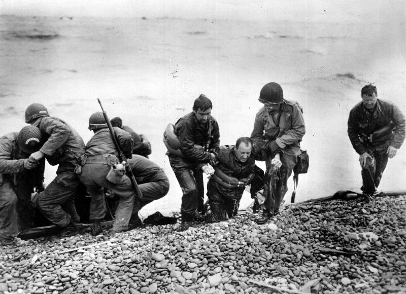 Des soldats américains aident d'autres personnes dont la péniche de débarquement a été coulée au large d'Utah Beach le jour J, 1944.