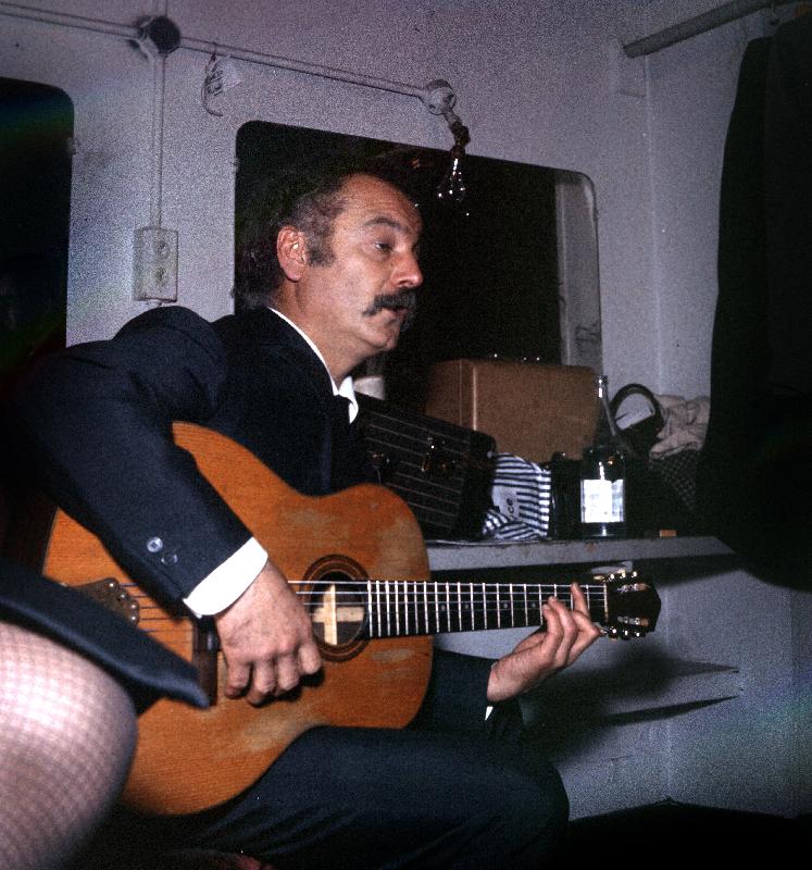 Photo de Georges Brassens jouant de la guitare, vers 1960